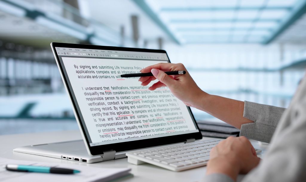 Edits digital word document copy being updated with stylus pen on laptop screen